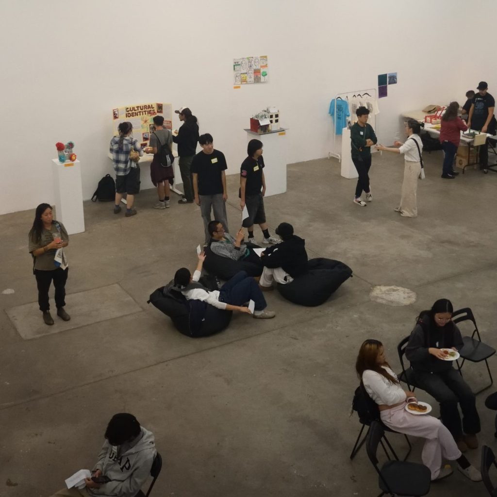 Image of students interacting with visitors during gallery event